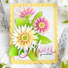 a close up of a card with flowers on it and the words mom spelled in cursive writing