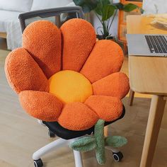 an orange flower shaped chair cushion sitting on top of a desk