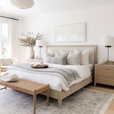 a bedroom with white walls and neutral furniture