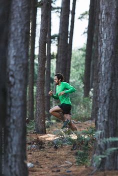 a man running through the woods on a trail