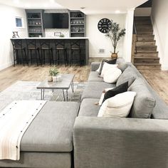 a living room filled with lots of furniture and a clock on the wall above it