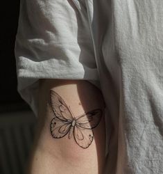 a small butterfly tattoo on the thigh