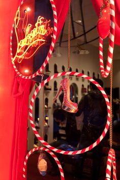 a window display with high heeled shoes and candy canes hanging from it's sides