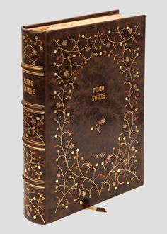 a brown book with gold trimmings on the front and back cover is shown