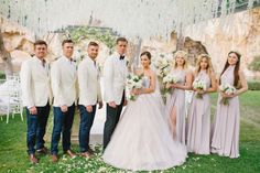 a group of people standing next to each other in front of a tree with white flowers