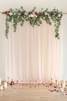 an arrangement of candles, flowers and greenery decorate the backdrop for a wedding ceremony