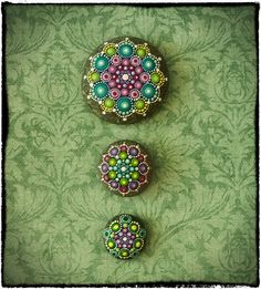 three buttons with beading on them sitting next to each other in front of a green wall