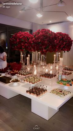 a table filled with lots of desserts and flowers in vases on top of it