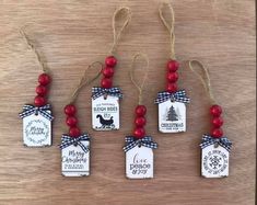 six christmas tags with red beads hanging from strings on a wooden surface, decorated with ribbon and snowflakes