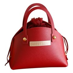 a red handbag with a bow on the top and name tag attached to it