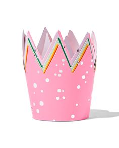 a pink paper crown with white polka dots and rainbow strips on the top, sitting in front of a white background