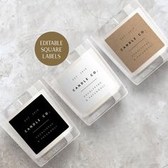 three candles in clear boxes with labels on the front and back, sitting next to each other