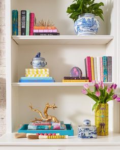 a shelf with books and vases on it