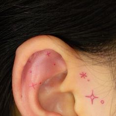 a close up of a person's ear with small stars on it