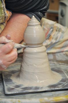 a person is working on a pottery piece