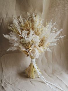 a bouquet of dried flowers sitting on top of a white sheet