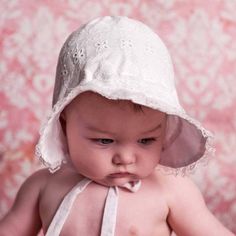 a small baby wearing a white hat