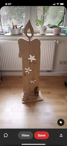 a wooden sculpture sitting on top of a hard wood floor next to a radiator