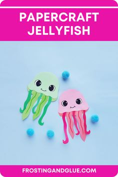 two paper jellyfishs are sitting next to each other on a blue background with pom poms