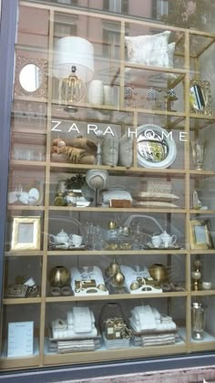 a store front window filled with lots of white and gold items in glass display cases