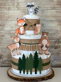 a three tiered cake with woodland animals on it