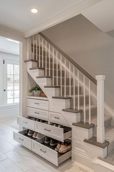 a white staircase with drawers underneath it and some shoes on the bottom shelf in front