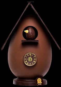 a chocolate egg shaped like a house with a clock on top