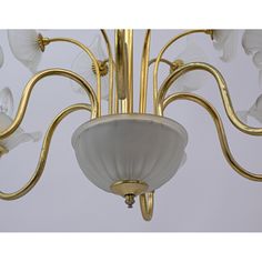 a gold chandelier with white flowers hanging from it