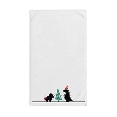 a white towel with two dinosaurs and a christmas tree on the front, against a white background