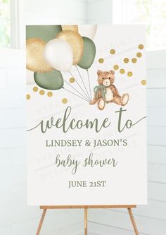 a welcome sign for a baby shower with balloons and a teddy bear in the air