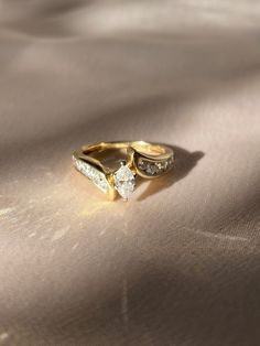 two gold wedding rings sitting on top of a bed