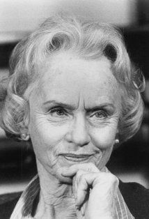 black and white photograph of an older woman with her hand on her chin looking at the camera