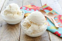 two bowls filled with ice cream on top of a wooden table