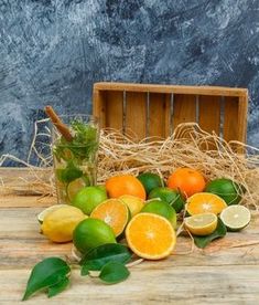 citrus fruit displayed on wooden table next to crate with straw bale and blue background