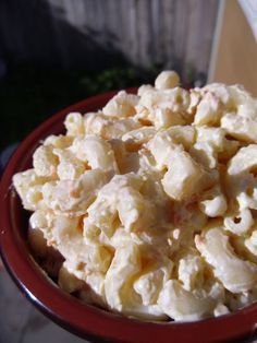 a red bowl filled with macaroni and cheese