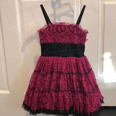 a pink and black dress hanging on a door