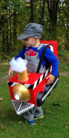 a little boy dressed up as a firetruck and holding a beer in his hand