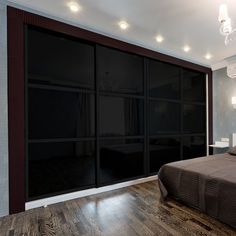 a bed sitting in a bedroom next to a sliding glass door with lights on it