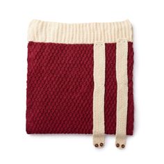 a red and white knitted bag with two straps on the front, sitting against a white background