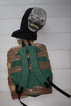 a backpack with a skeleton head on it sitting on the floor next to a bag