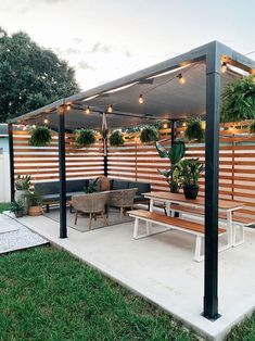 a covered patio with seating and potted plants