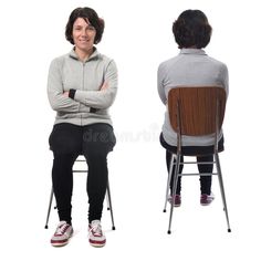 two women sitting on chairs with their arms crossed and looking at each other royalty images