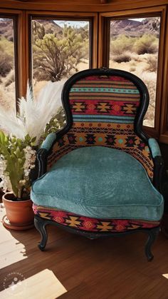 a chair sitting in front of a window next to a potted plant