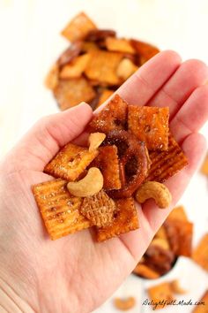 a hand holding some kind of snack in it's palm, next to other snacks