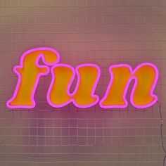 a neon sign that says fun on the side of a wall with tile behind it