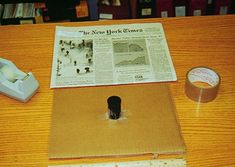 an open box sitting on top of a wooden table next to a tape dispenser