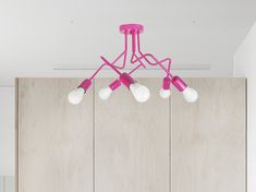 a pink chandelier hanging from the ceiling in a room with wood paneling