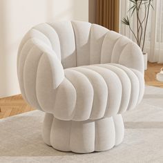 a large white chair sitting on top of a rug