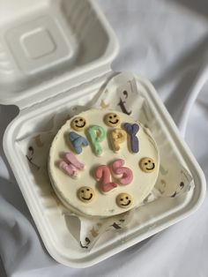 a cake in a plastic container with smiley faces on it