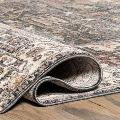 an area rug on the floor with a wooden floor and wood floors in the background